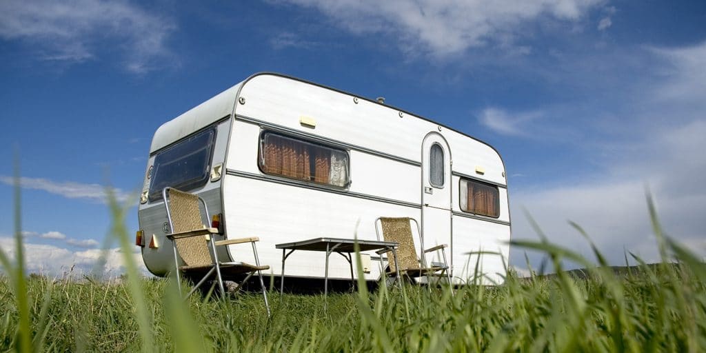 Witte caravan op een grasveld
