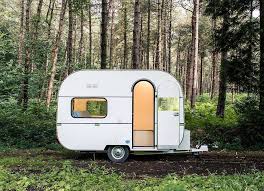 Witte caravan op een kampeerplek in het bos